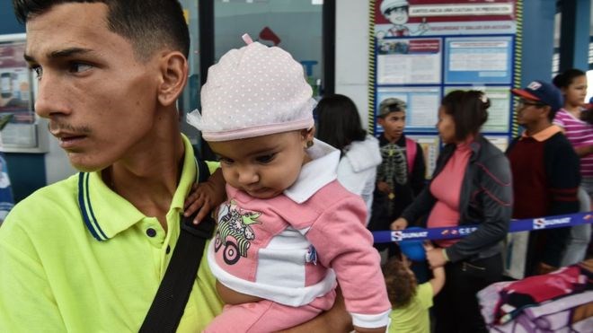 En pappa med sitt barn i ett av Caritas hjälpcenter i Caracas