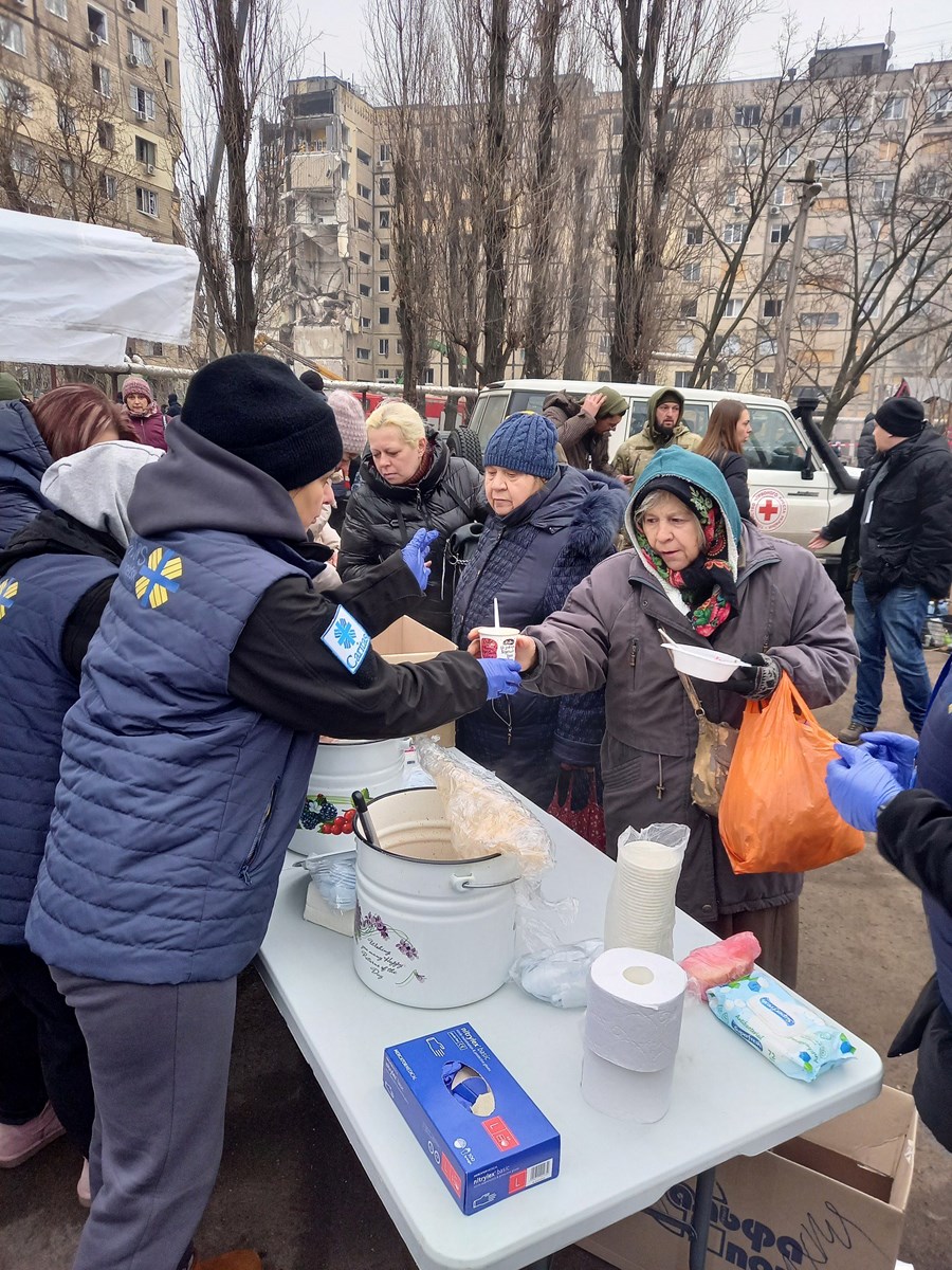 Caritas delar ut varm soppa utanför det bombade huset i Dnipro. Foto: Caritas Ukraine